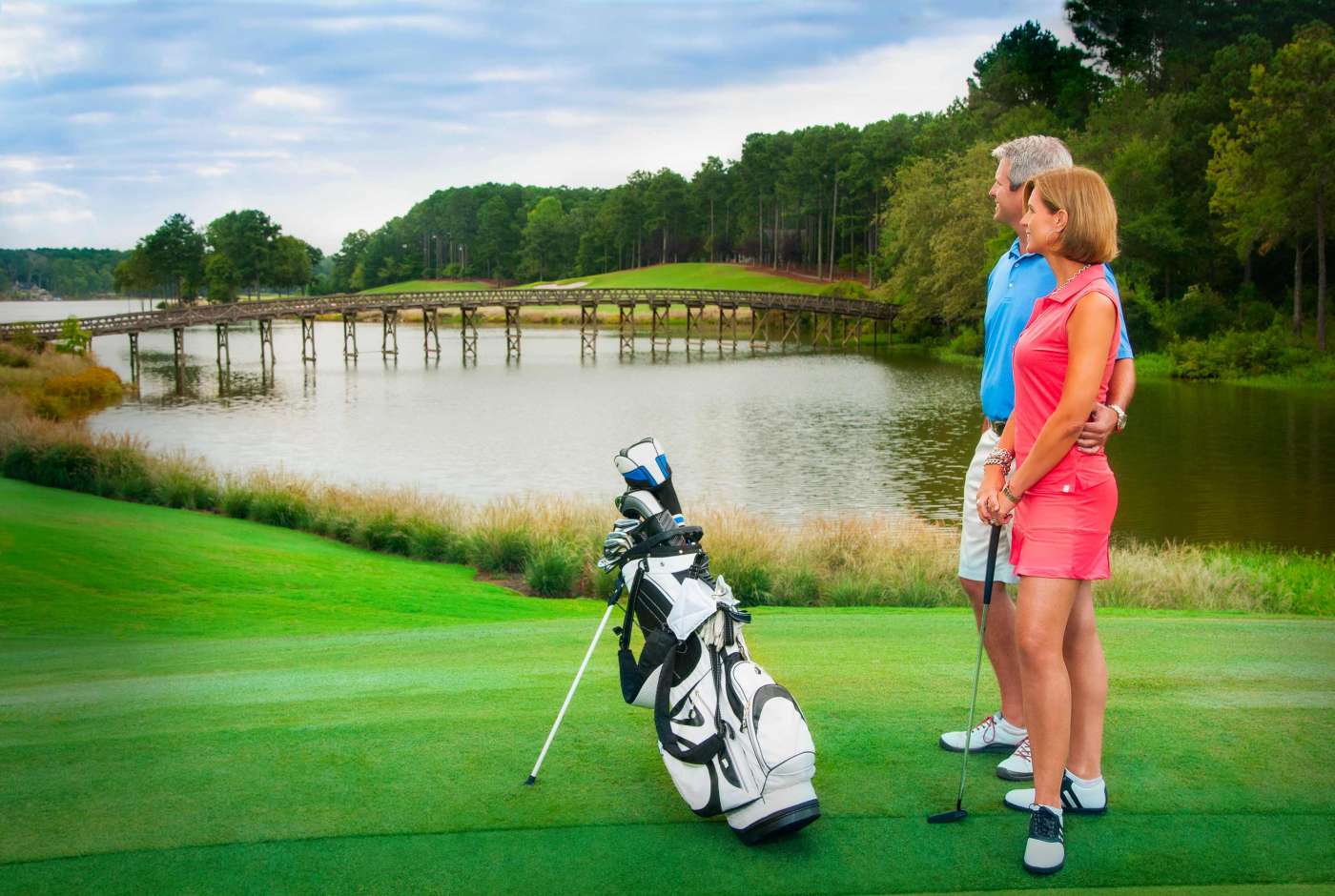 A couple gaze romantically across a beautiful lake along a golf course in Georgia.