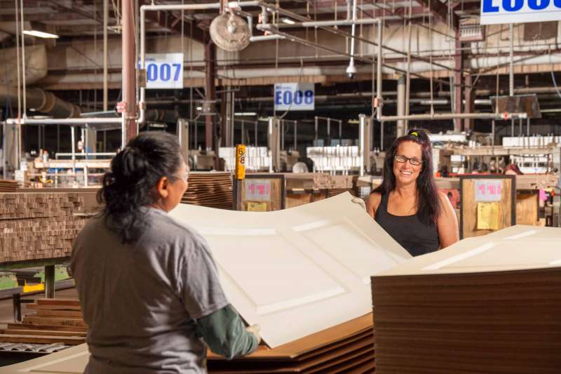 Two women inspect door skins at a door manufacturing facility in Hartselle, Alabama.
